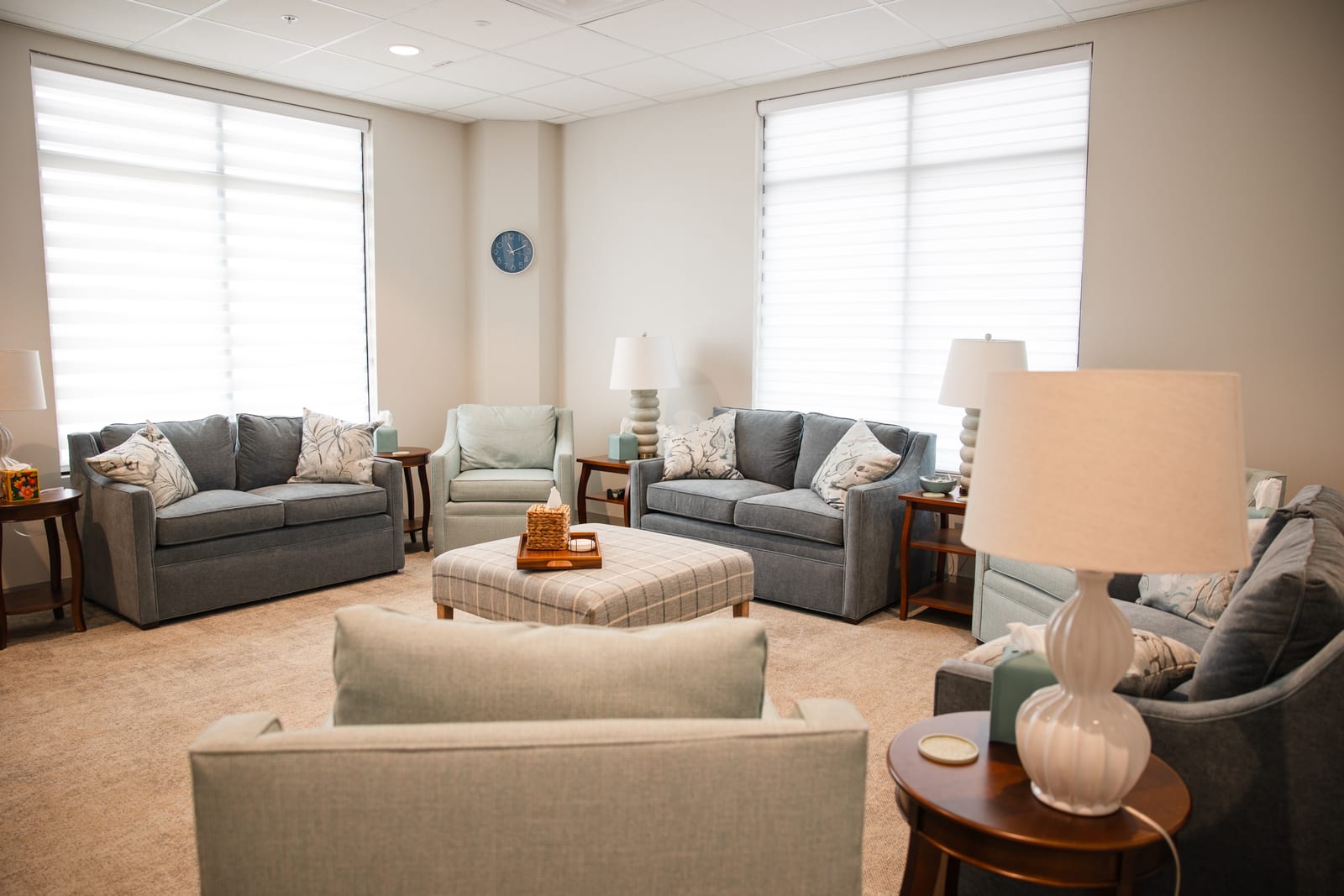 A corner of the Hope waiting room, with lamps, cushions and daylight through the blinds