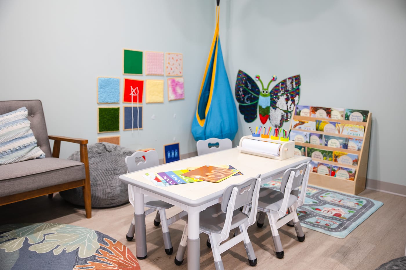 The children's room, with a hanging swing seat, a low art table and shelves of books