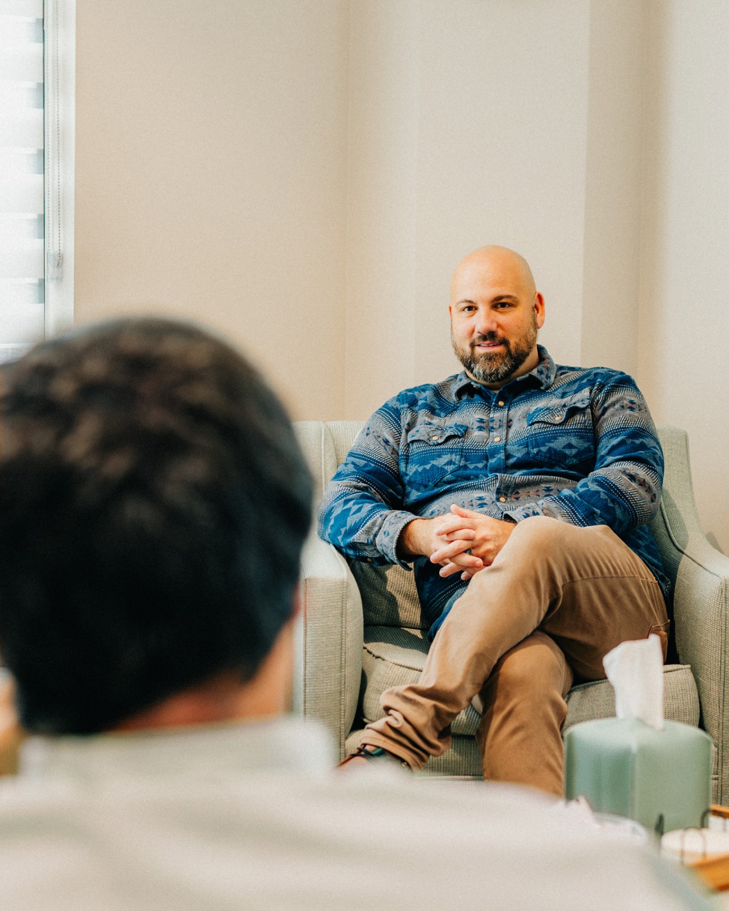 A provider listening to a client across his counseling room